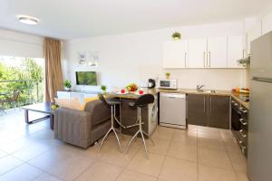 a kitchen and living room with a couch and a table at Lucile - Coralli Beachfront Apartment in Paralimni