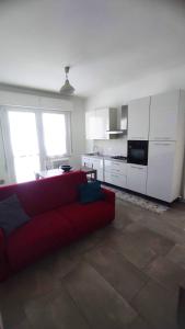sala de estar con sofá rojo y cocina en Appartamento Gabriele, en Cattolica