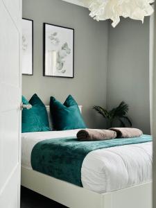 1 dormitorio con 1 cama con almohadas azules en Modern 2-bed flat in town centre, en Oban