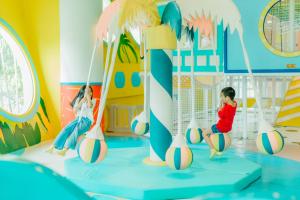 a boy and a girl playing volleyballs in a playground at A-One The Royal Cruise Hotel Pattaya - SHA Extra Plus in Pattaya Central