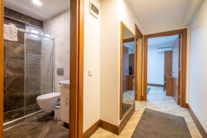 a bathroom with a toilet and a glass shower at The Dream Suite İstanbul in Istanbul