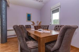 uma sala de jantar com uma mesa de madeira e cadeiras em Deluxe Holiday Home-Podgorica em Podgorica