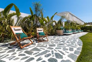 two chairs sitting on a stone walkway with plants at Voger Alaçatı Prive in Cesme