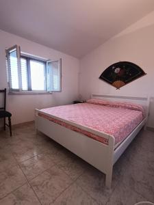una camera con un letto in una stanza con una finestra di Villa Marina a Sorso