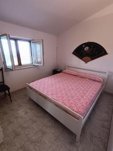 una camera con letto e piumone rosa di Villa Marina a Sorso