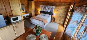1 dormitorio con 1 cama en una habitación de madera en Tegwaan's Nest B&B, en Mooi River
