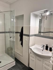a white bathroom with a sink and a shower at Apartament Juhas in Limanowa