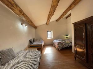 um quarto com duas camas e uma cadeira em L'Oustal de la Calade em Valleraugue