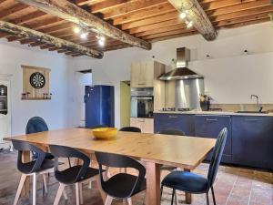 uma cozinha com uma mesa de madeira e cadeiras em L'Oustal de la Calade em Valleraugue