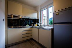 a kitchen with white cabinets and a sink and a window at Apartment ALBA in Bovec