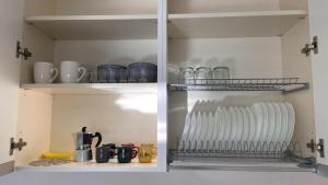 a refrigerator filled with lots of dishes and cups at Federica's house Rimini [150 mt dal mare] in Rimini