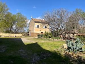 une vieille maison dans une cour avec une cour d'herbe sidx sidx sidx dans l'établissement Domaine Saint Martin le grand, à Béziers