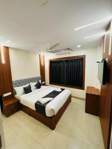 a bedroom with a large bed and a television at Royal Plaza City in Kozhikode
