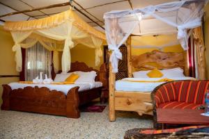 - une chambre avec 2 lits à baldaquin et un canapé dans l'établissement Explore Nature Lodge, à Ololaimutiek