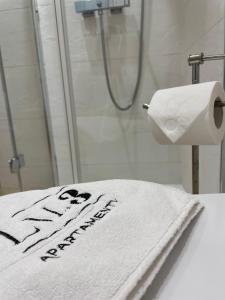 uma casa de banho com uma toalha que diz nova chegada em LM Axis Apartment em Kielce