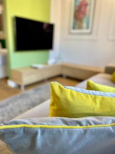 um sofá com duas almofadas amarelas numa sala de estar em LM Axis Apartment em Kielce