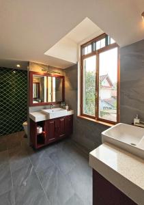 琅勃拉邦的住宿－PHA NYA RESIDENCE，一间带两个盥洗盆的浴室和一个大窗户