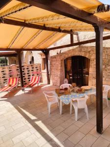 a patio with a table and chairs and a stone fireplace at LocoMura in Locorotondo