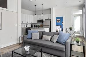 a living room with a couch and a kitchen at Spacious 2BD with Private Balcony and Free Parking in Charlotte