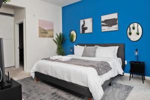 a bedroom with a large bed with a blue wall at Spacious 2BD with Private Balcony and Free Parking in Charlotte