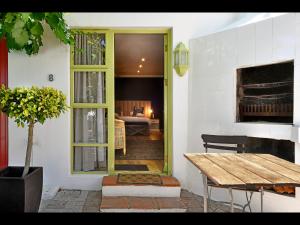 Una puerta a una habitación con una mesa y un dormitorio en Ashbourne Boutique Guest House, en Franschhoek
