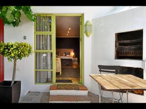 a door to a room with a table and a bedroom at Ashbourne Boutique Guest House in Franschhoek