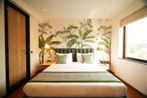 a bedroom with a large bed with a plant wallpaper at The LIV Hotel Jaipur in Jaipur