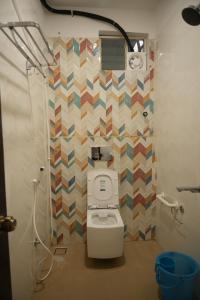 a bathroom with a toilet and a geometriciled wall at SABA SERVICE APARTMERNT in Hyderabad