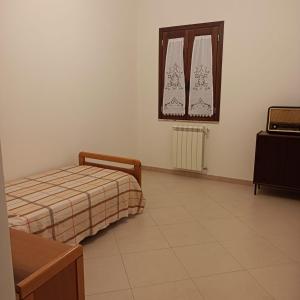 1 dormitorio con cama, espejo y TV en Casa vacanza Acquanuova, en Calatafimi