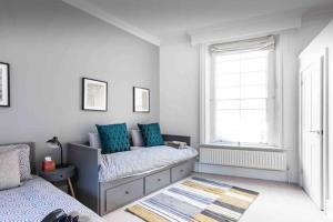 a bedroom with a bed with blue pillows and a window at 4 beds - 2 bathroom Apartment, New Oxford Street in London