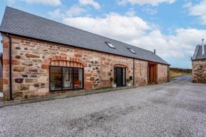 an old stone building with a driveway in front at Windhover Barn in Annbank