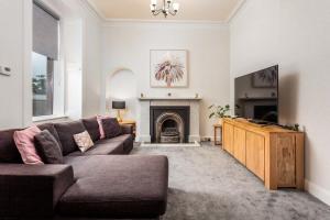 uma sala de estar com um sofá e uma lareira em Castlehill Road em Ayr