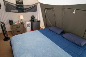 a bedroom with a blue bed in a tent at Moab RV Resort Glamping Setup Tent OK-T3 in Moab