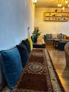 sala de estar con sofá azul y alfombra en House of Nomad, en Gangtok