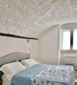 1 dormitorio con 1 cama con edredón azul en Casa Raffaella, en Monopoli