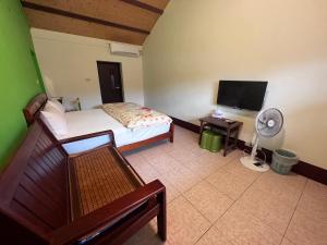 a bedroom with a bed and a flat screen tv at Color Rainbow Home in Taimali