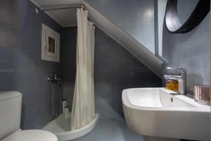 a bathroom with a shower curtain and a sink at Port loft in Mantoúkion