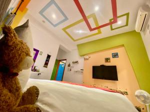 un orsacchiotto seduto su un letto in una camera da letto di 鐵花108 民宿 a Città di Taitung