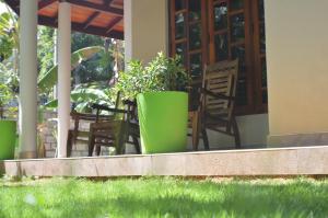 um pátio com cadeiras e plantas num alpendre em Binara Home Stay em Pollonaruva