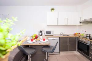 a small kitchen with a table and chairs in it at Lucile - Coralli Beachfront Apartment in Paralimni +30 photos