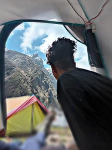 um homem olhando pela janela de uma tenda em Rajwan peradise tents em Kedārnāth