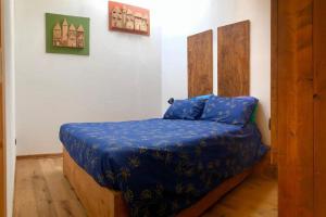 a bedroom with a bed with a blue comforter at L'Oretta Moena Fata delle Dolomiti in Moena