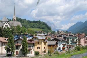 una ciudad en las montañas con una iglesia en L'Oretta Moena Fata delle Dolomiti, en Moena