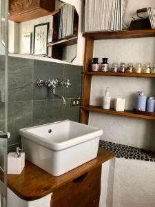 La salle de bains est pourvue d'un lavabo blanc sur un comptoir en bois. dans l'établissement L'Oretta Moena Fata delle Dolomiti, à Moena