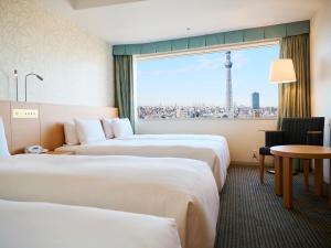 two beds in a hotel room with a view of the eiffel tower at Tobu Hotel Levant Tokyo in Tokyo