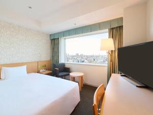 a hotel room with a bed and a large window at Tobu Hotel Levant Tokyo in Tokyo