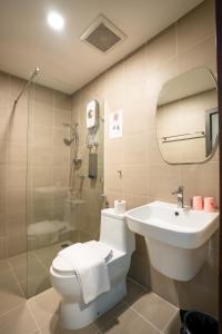 a bathroom with a toilet and a sink and a shower at Siri Hotel in Vientiane