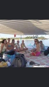 um grupo de pessoas sentadas no chão perto da água em Salah El Din Restaurant on the Nile Corniche em Aswan