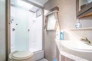 a bathroom with a shower and a toilet and a sink at Moab RV Resort Glamping RV Setup OK33 in Moab
