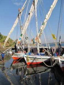 Un barco está atracado en el agua con gente en él. en Salah El Din Restaurant on the Nile Corniche en Asuán